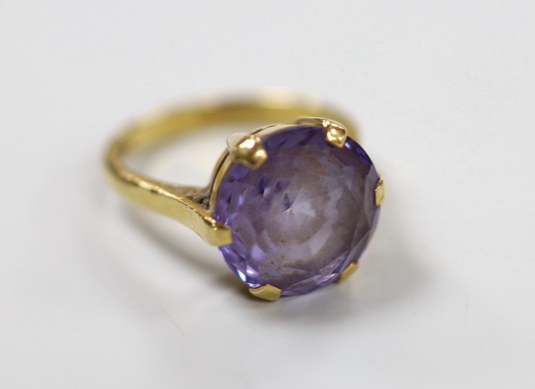 An 18ct and synthetic colour change corundum set dress ring, size O, gross weight 6.5 grams.